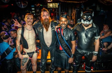 The Laird Melbourne event: four gay men in leather gear, one in a puppy mask, posing at a gay bar. Leather and fetish scene.