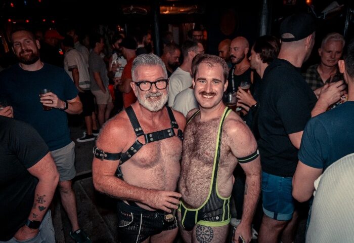 The Laird Melbourne: Two gay men pose at a leather night. One wears a harness, the other a singlet. Gay travel advice.