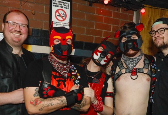 Gay men at The Laird Melbourne pub wearing puppy gear, including masks and harnesses. Leather and bandanas complete the playful attire.