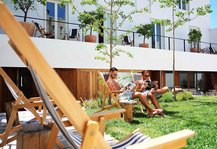 The Late Birds Lisbon Gay Urban Resort: Men relaxing in lounge chairs on the lawn of this popular gay hotel, enjoying the sun.