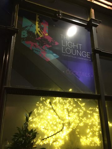 The Light Lounge gay bar sign in London. Cocktail bar with colorful modern art. Interior view with lights. Gay travel advice.