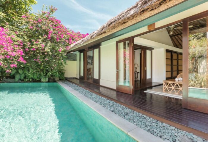 The Pavilions Bali gay-friendly hotel pool view. Tropical villa with private pool, wood deck, and bougainvillea. Bali gay travel.
