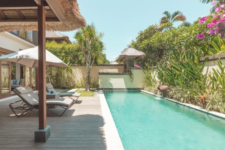 The Pavilions Bali gay-friendly hotel pool view. Luxury villa with sunbeds and tropical garden. Bali travel for gay men.