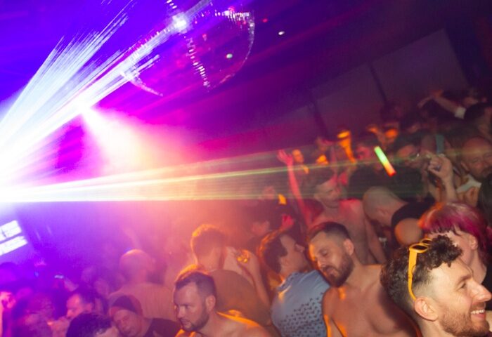 The Peel Hotel Melbourne: A crowded gay bar with shirtless men, disco ball, and bright lights. Gay travel advice.