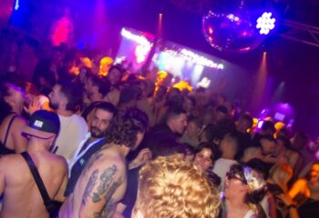 Crowd at The Peel Hotel, Melbourne. Gay bar with disco ball and stage. Nightlife scene for gay men's travel advice.