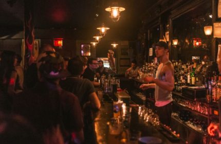 Interior of The Phoenix Gay Bar in New York. Bartender serving drinks at a busy bar. A popular gay bar and travel destination.