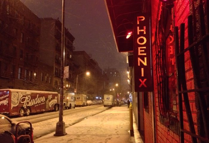 The Phoenix Gay Bar in New York City on a snowy night. Red neon sign. Gay travel advice. LGBTQ+ nightlife.