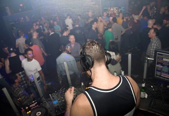 Vancouver's Pumpjack Pub: DJ spins tunes for a lively crowd. Popular gay travel destination for nightlife and entertainment.