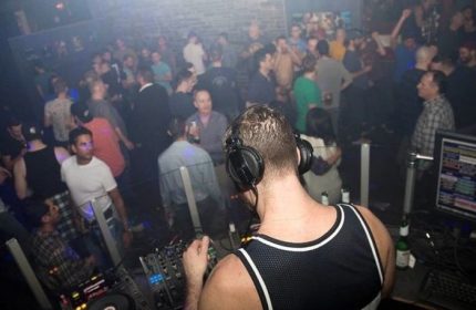 Vancouver's Pumpjack Pub: DJ spins tunes for a lively crowd. Popular gay travel destination for nightlife and entertainment.