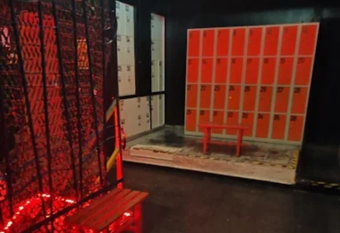 The Ring Private Gay Cruise Club in Madrid: Lockers and benches inside a dark room, lit with red light. Gay travel destination.