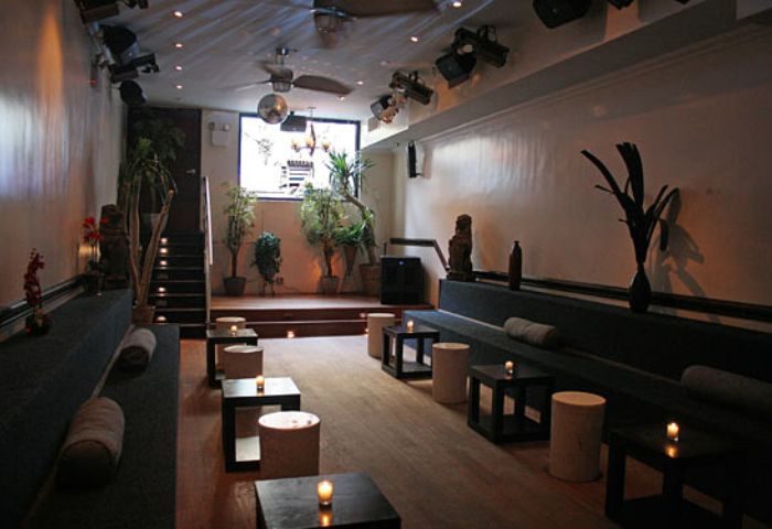 The Ritz Bar and Lounge in New York: Stylish interior with seating, plants, and lighting. A great gay travel spot for drinks and socializing.