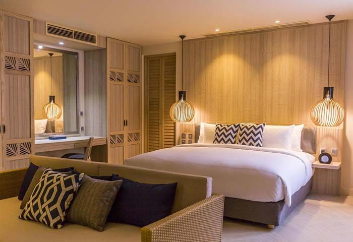 The SIS Kata Resort gay-friendly hotel room. Modern design, wooden accents, king bed, sofa, and stylish lamps. Phuket gay travel.