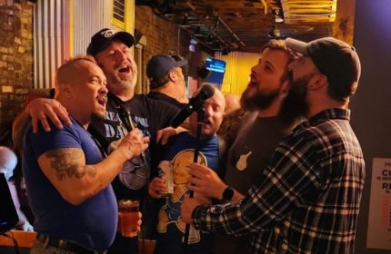 Gay bear bar fun: SoFo Tap in Chicago shows a group of men singing karaoke, enjoying drinks, and having a great time at this popular gay bar.