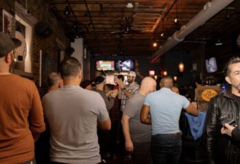 Inside The SoFo Tap, a Chicago gay bear bar. A group of men are gathered, some watching TVs in this popular gay bar.