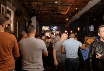 Inside The SoFo Tap, a Chicago gay bear bar. A group of men are gathered, some watching TVs in this popular gay bar.