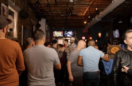 Inside The SoFo Tap, a Chicago gay bear bar. A group of men are gathered, some watching TVs in this popular gay bar.
