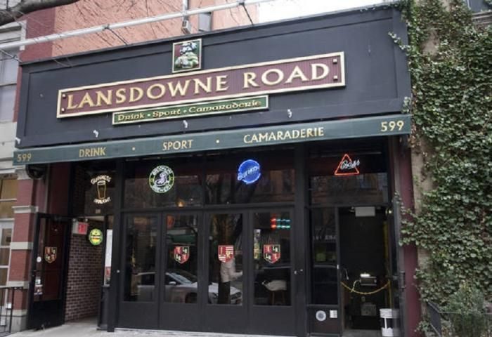 Lansdowne Road: The Spot in New York. A gay-friendly bar with Drink, Sport, Camaraderie signage. Neon beer signs adorn the entrance.