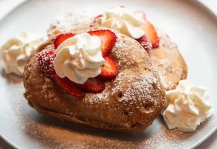 The Spot in New York: French toast topped with strawberries and whipped cream. A delicious breakfast treat for gay travelers in New York.
