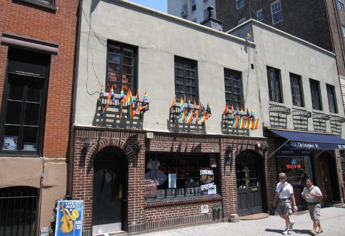 The Stonewall Inn, New York. Historic gay bar with rainbow flags, a landmark for LGBTQ+ travel. Gay men travel advice in NYC.