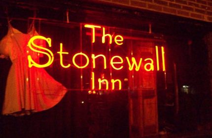 The Stonewall Inn in New York. Neon sign with dress. Gay travel destination. LGBTQ+ landmark. Historic gay bar. Gay men's travel advice.
