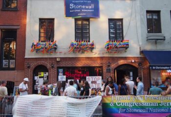 The Stonewall Inn in New York, a gay bar and historic landmark, is decorated with rainbow flags. People gather outside the Stonewall National Monument.
