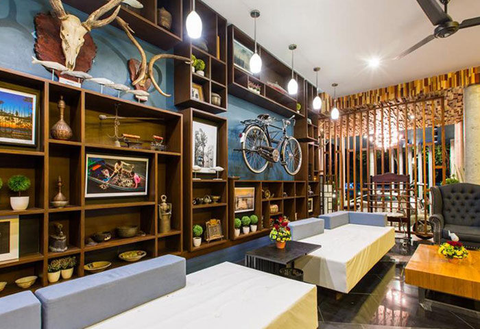 The Tama Hotel chic interior. Krabi gay hotel near Railay Beach with cheap price. Stylish lobby with shelves, bike decor, and seating.