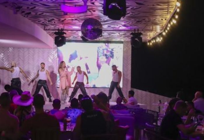 Sky Gay Bar in Puerto Vallarta: Performers onstage entertain a crowd. Nightlife scene, popular gay travel destination.