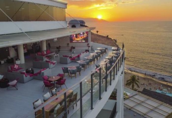 Puerto Vallarta gay travel: Top Sky Bar view at sunset. Outdoor seating, ocean views, and stylish decor. A must-visit gay bar in PV.