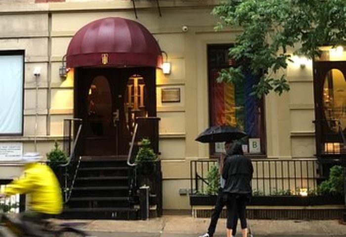 The Townhouse Bar in New York City. Gay travel destination with rainbow flag visible in window. Elegant bar exterior on a rainy day.