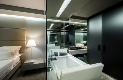 The Vine Hotel, Madeira: Stylish room with bed, lamp, and bathtub. Gay-friendly design offers luxury for discerning travelers.
