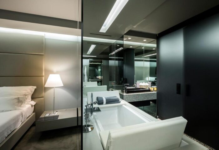 The Vine Hotel, Madeira: Stylish room with bed, lamp, and bathtub. Gay-friendly design offers luxury for discerning travelers.