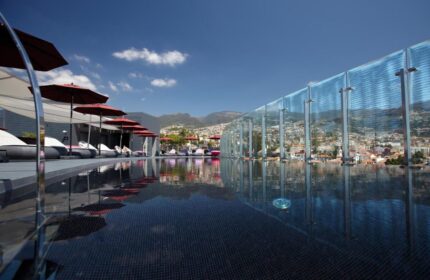 The Vine Hotel, a gay-friendly hotel in Madeira. Rooftop pool with city views, umbrellas, and lounge chairs. Perfect for gay travel.