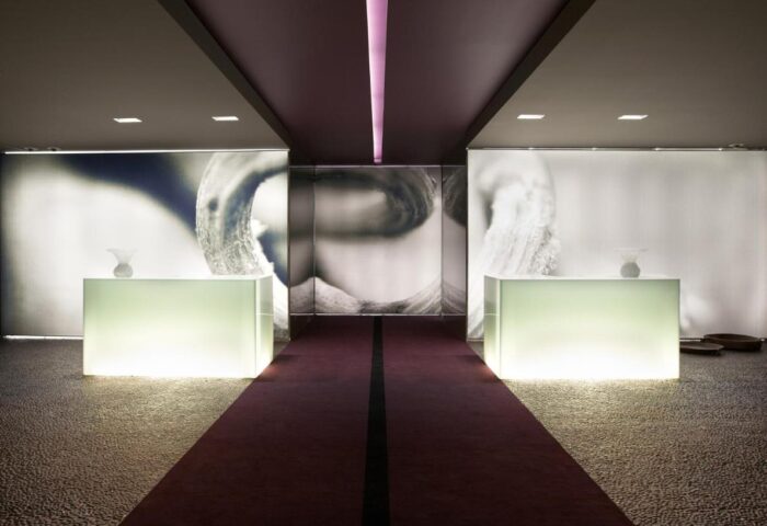 The Vine Hotel lobby. Gay-friendly hotel with modern design, illuminated desks, and a purple carpet. Stylish and welcoming space.