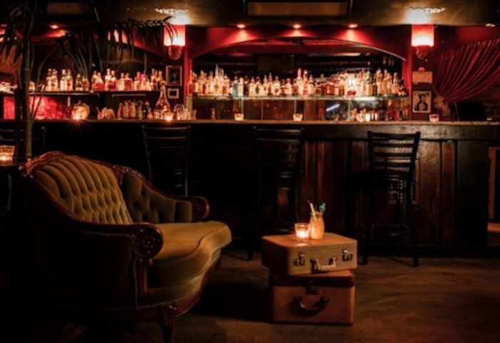 The Wiggle Room gay bar in Montreal. Vintage couch, suitcases as tables, and a fully stocked bar create an intimate ambiance for a live show.