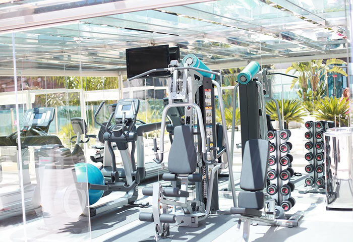 Hotel Indigo Barcelona Plaza Catalunya gym. Treadmills, weights, and fitness equipment in a modern gym with glass walls. Best gay hotel Barcelona.