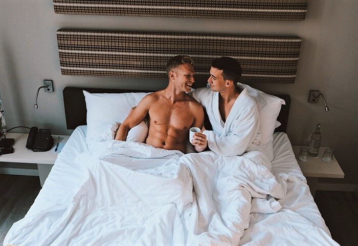 Gay Amsterdam honeymoon: Two men in bed at The Albus Hotel, Amsterdam City Centre. Gay couple enjoying their stay in Amsterdam.