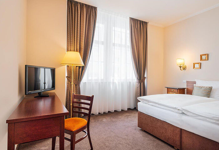 Hotel Leonardo Prague room. This gay-friendly hotel in Prague's Old Town offers comfortable lodging. Features include a desk, TV, and cozy bed.