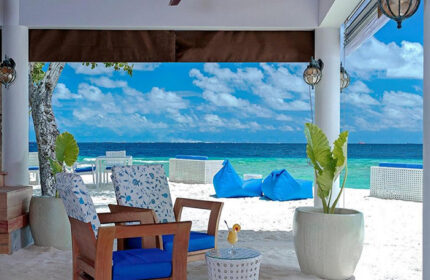 Beachfront view from Malahini Kuda Bandos Resort, Maldives. Gay-friendly hotel with blue cushions, beanbags, white sand, and ocean views.