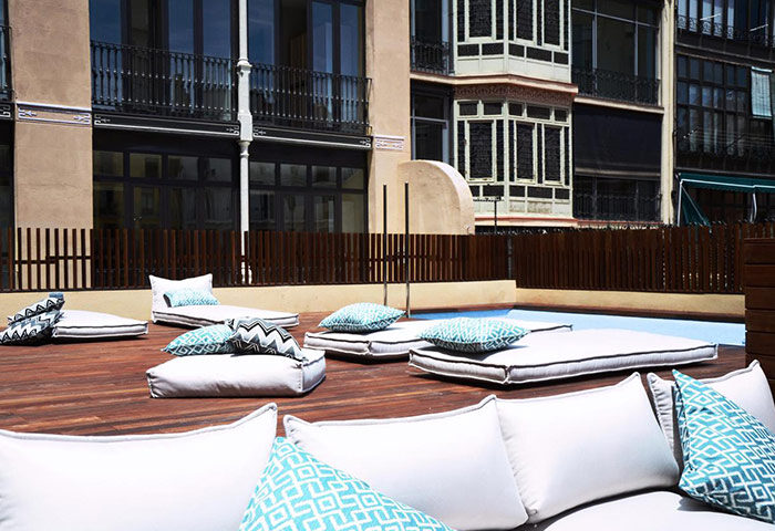 TOC Hostel Barcelona pool area. This popular gay hostel features stylish outdoor lounge seating for relaxing by the pool. A great Barcelona travel choice.