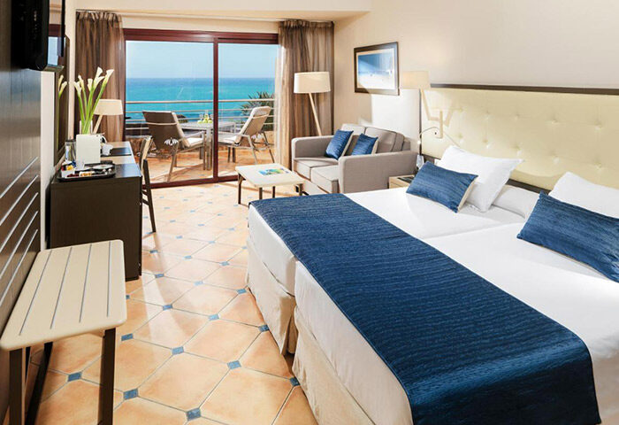 H10 Playa Meloneras Palace gay hotel room. Adults-only, sleeps three. Balcony with ocean view. Modern design, comfortable for gay travelers.