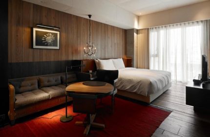Hotel Proverbs Taipei room. Gay Pride hotel list update. Wood paneled wall, sofa, table, bed, and chandelier. Gay travel advice.