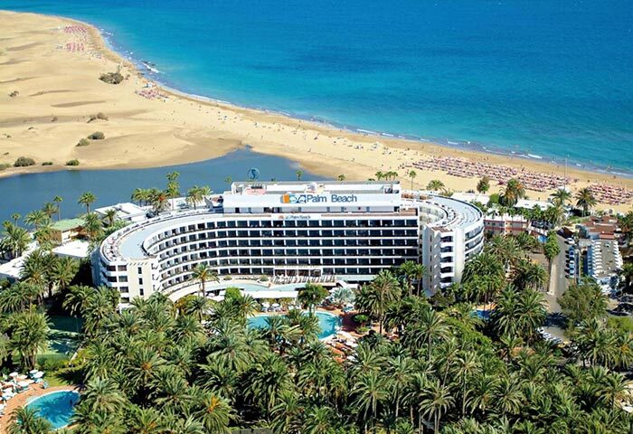 Seaside Palm Beach hotel aerial view. Best 5-star gay hotel on Maspalomas gay beach. Gay travel destination. Palm trees, beach, ocean.
