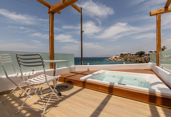 Poseidon Hotel Suites rooftop hot tub in Mykonos Town. Best gay hotel with private jacuzzi, seating area, and ocean view. Gay travel advice.