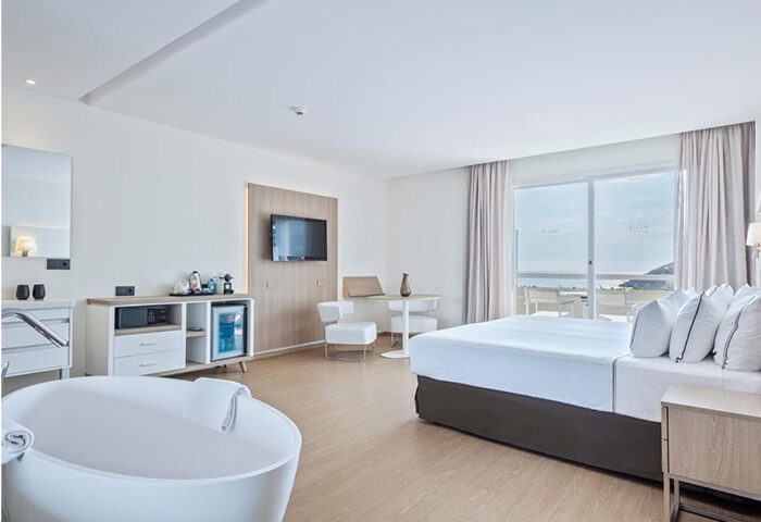 Melia Sitges hotel room. Modern interior with a bed, bathtub, and balcony overlooking the sea. Best gay hotel in Sitges with pool.