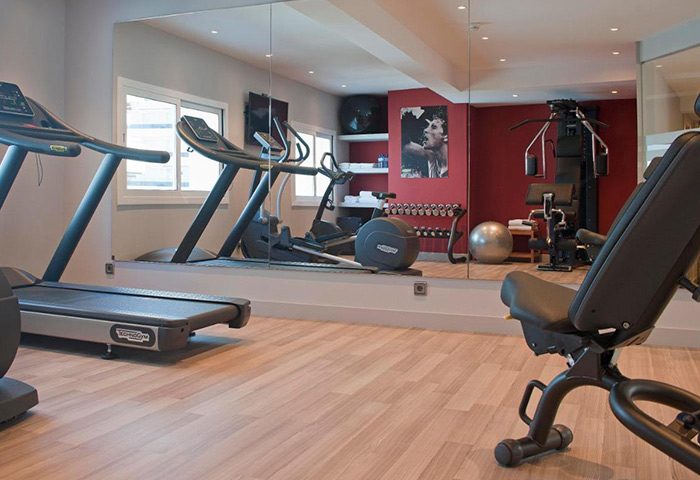 Hotel Calipolis gym with treadmills, weights, and workout equipment. A great amenity at this gay-friendly hotel near Playa De la Bassa Rodona.
