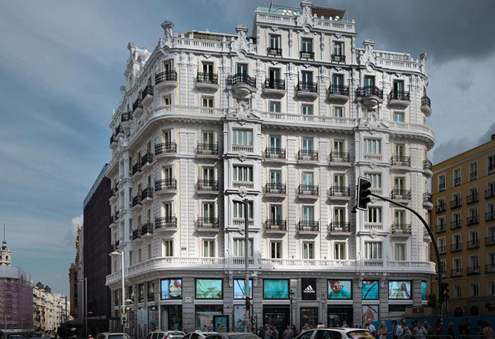NH Collection Madrid Gran Via, best gay hotel in Madrid's gayborhood. Ornate white building with balconies, street view.