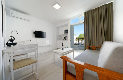Atlantic Sun Beach gay men only hotel room. Playa del Ingles, Gran Canaria apartment interior with kitchen, table, and sofa.