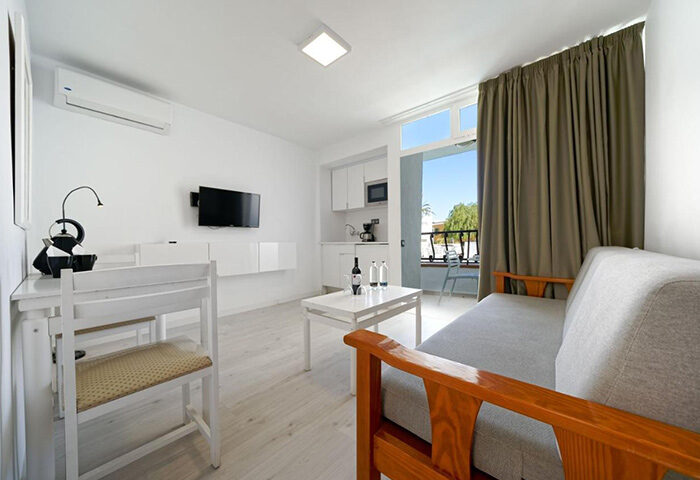Atlantic Sun Beach gay men only hotel room. Playa del Ingles, Gran Canaria apartment interior with kitchen, table, and sofa.