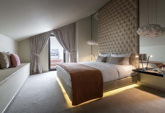 9Hotel Mercy Lisbon room. Best honeymoon gay hotel update. Bedroom interior with bed, headboard, balcony, and modern design. Gay travel advice.