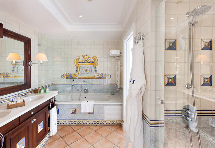 Seaside Grand Hotel Residencia Gran Lujo bathroom. Best luxury gay hotel near gay beach. Shower, bath, robe, and decorative tiles.